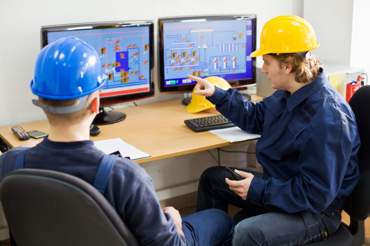 construction workers at work in control room with computers.Photos on monitors are my photos